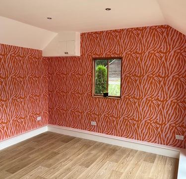 Bold red and pink zebra print wallpaper and light oak laminate flooring in Sussex.