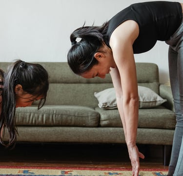 a woman and a child are standing on a rug doing stretching exercises