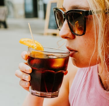 Woman enjoying a vermouth on Santa Lola Badalona terrace.