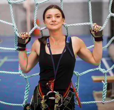 a woman in a black top and climbing harness