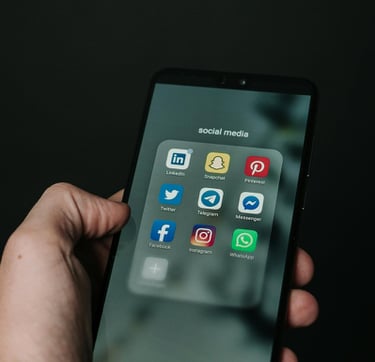 Téléphone mobile dans une main, illustrant différents réseaux sociaux