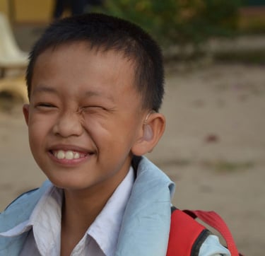a young boy with hearing aid on his head