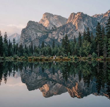 A sophisticated nature shot of a North American / US mountain range during the blue hour. The style is clean and artistic, featuring deep Sage Green forests and Stone Khaki rock faces under a Mist White misty sky, reflecting the couple's appreciation for the natural world.