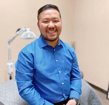 Dr. Xiong in a blue button-down shirt at Balance Naturopathic & Acupuncture Clinic.