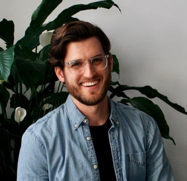 John smiling with plant behind him