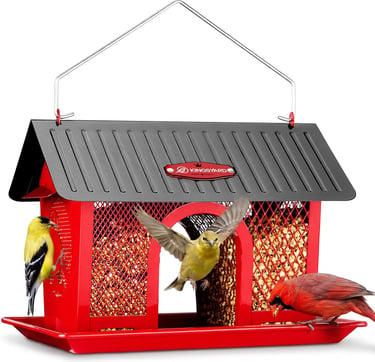 Red metal bird feeder with a cardinal and finches eating from a mesh seed container.