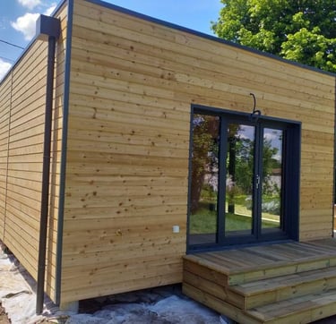une maisonette ne cube avec un bardage bois avant peinture bois brut sapin