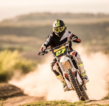 Person riding a dirt bike and wearing a protective eyewear
