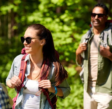 People hiking in the woods and wearing a sunglasses