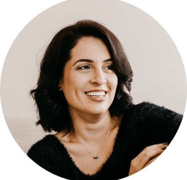 A smiling professional woman with short dark hair wearing a black fuzzy sweater in a profile headshot.
