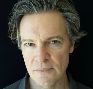 Closeup headshot of Todd Long with medium-short hair and serious expression