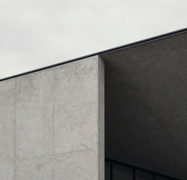 A high-end, minimalist architectural detail of a modern Northern European gallery. The composition features sharp lines of light gray concrete against a soft off-white sky. The lighting is diffused and natural, creating a sophisticated and artistic mood with a palette of light gray and charcoal black.
