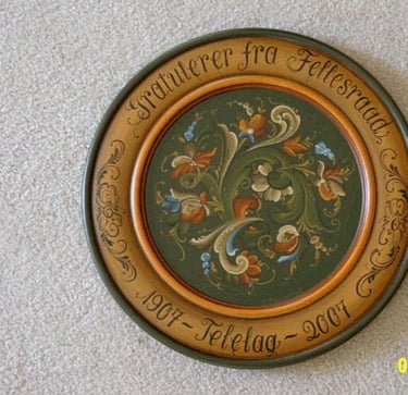 A green and gold rosemaled plate