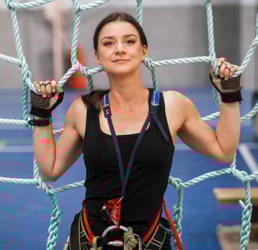 a woman in a black top and climbing harness