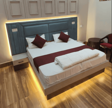 a bed with a bed and a chair - Rasa veda Hotel  Shikohabad