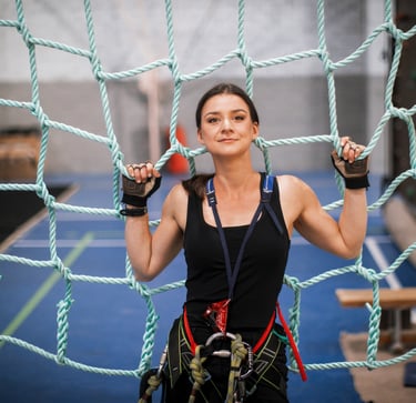 a woman in a black top and climbing harness