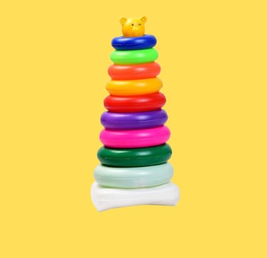 a stack of colorful plastic toys on a yellow background