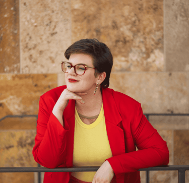 Swana Schuchmann, mit rotem Blazer. Sie schaut in die Ferne.