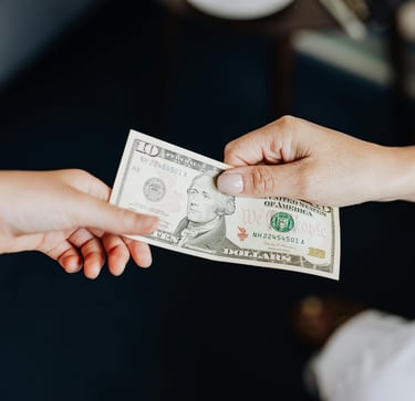 two people holding onto a dollar bill representing gold ira fees and a guide to understanding gold ira fees
