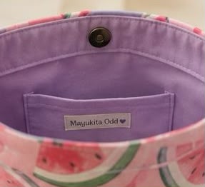 Interior bolso tipo tote con estampado de sandía rosa, forro morado y cierre de botón magnético
