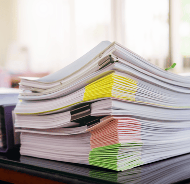 a stack of papers on top of a desk