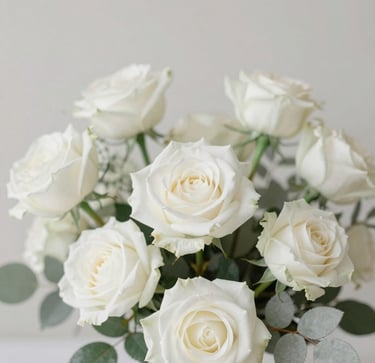 Elegant soft-focus photo of white roses and delicate botanical leaves, minimalist romantic background