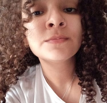a woman with curly hair and a white shirt