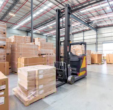 a forklift truck in a warehouse with boxes of boxes
