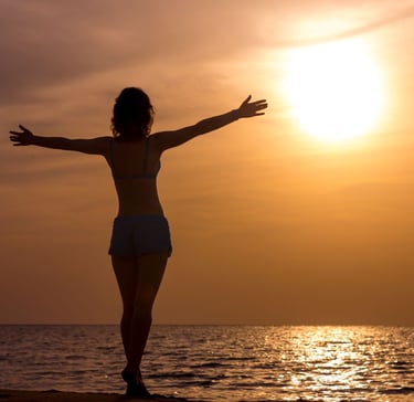 femme libre et heureuse qui regarde l'horizon en levant les bras