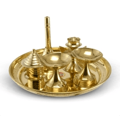 small brass items for pooja placed in a plate