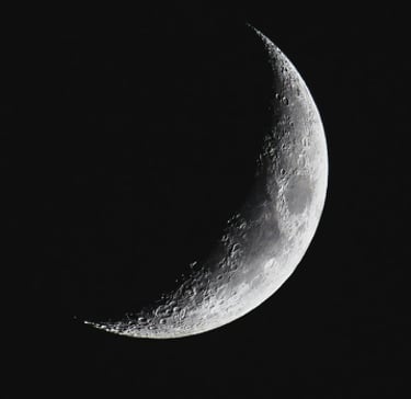 a crescent moon in the dark sky