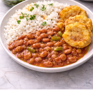 Puerto Rican habichuelas guisadas stewed red beans served with white rice and tostones on a plate