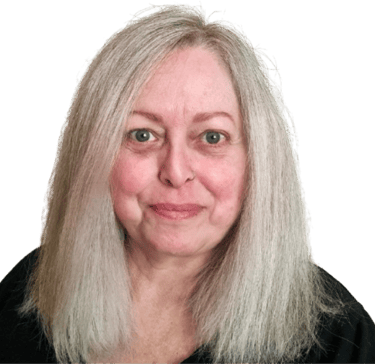 A middle aged white woman with long blonde hair, geen eyes, and wearing a black top