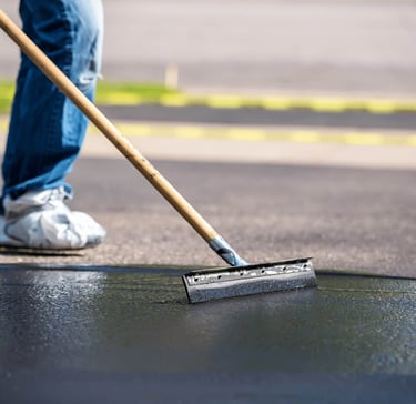 Applying emulsion asphalt sealant to driveway