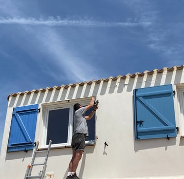 menuisier artisan en Vendée en train de réaliser l'installation d'un volet battant