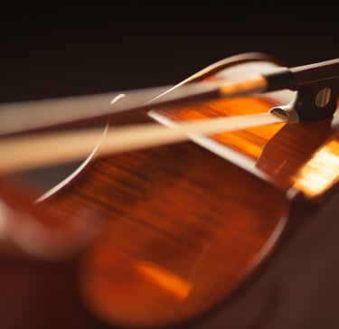 Cello laid on its side with a bow laying across the ribs