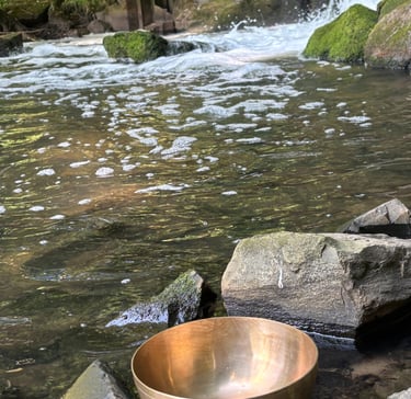 Klangschale steht behutsam am Wasser.
