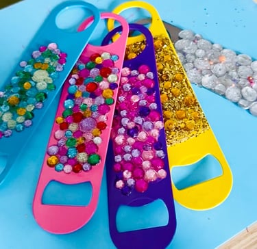 multicolored flat bottle openers covered in rhinestones and glitter