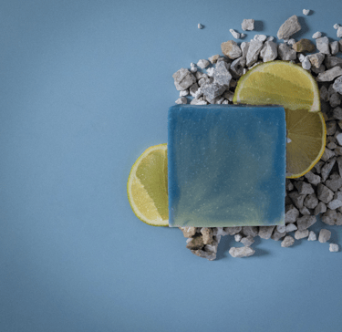 a soap bar with a slice of lemonade on top of a pile of rocks