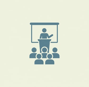 Flat icon of a speaker at a podium giving a presentation to an audience in a classroom or seminar.