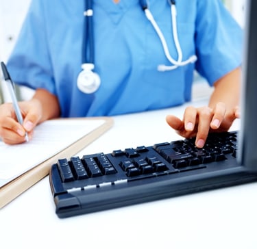 Nurse typing documentation on the keyboard..