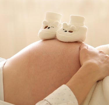 Barriga de embarazada con patucos encima