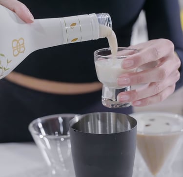 a woman pouring a drink into a glass