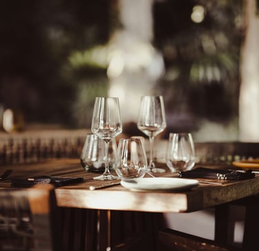a table with wine glasses in a restaurant.Sustainability in Hospitality with Timea Pokol Consultant