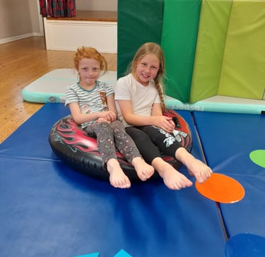 two girls practicing pointy toes in SEND gymnastics session