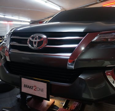 Toyota en elevador durante servicio de frenos en taller automotriz especializado