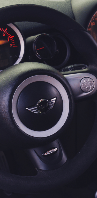 a car dashboard with a steering wheel and dashboard controls