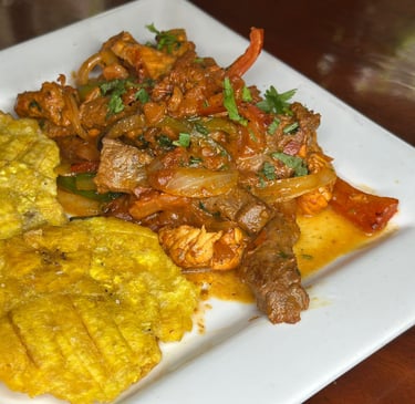 a plate of food with a mix of chicken beef and pork and tostones
