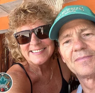 Jo Schultz wearing sunglasses, smiling and hugging behind her husband.