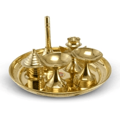 small brass items for pooja placed in a plate